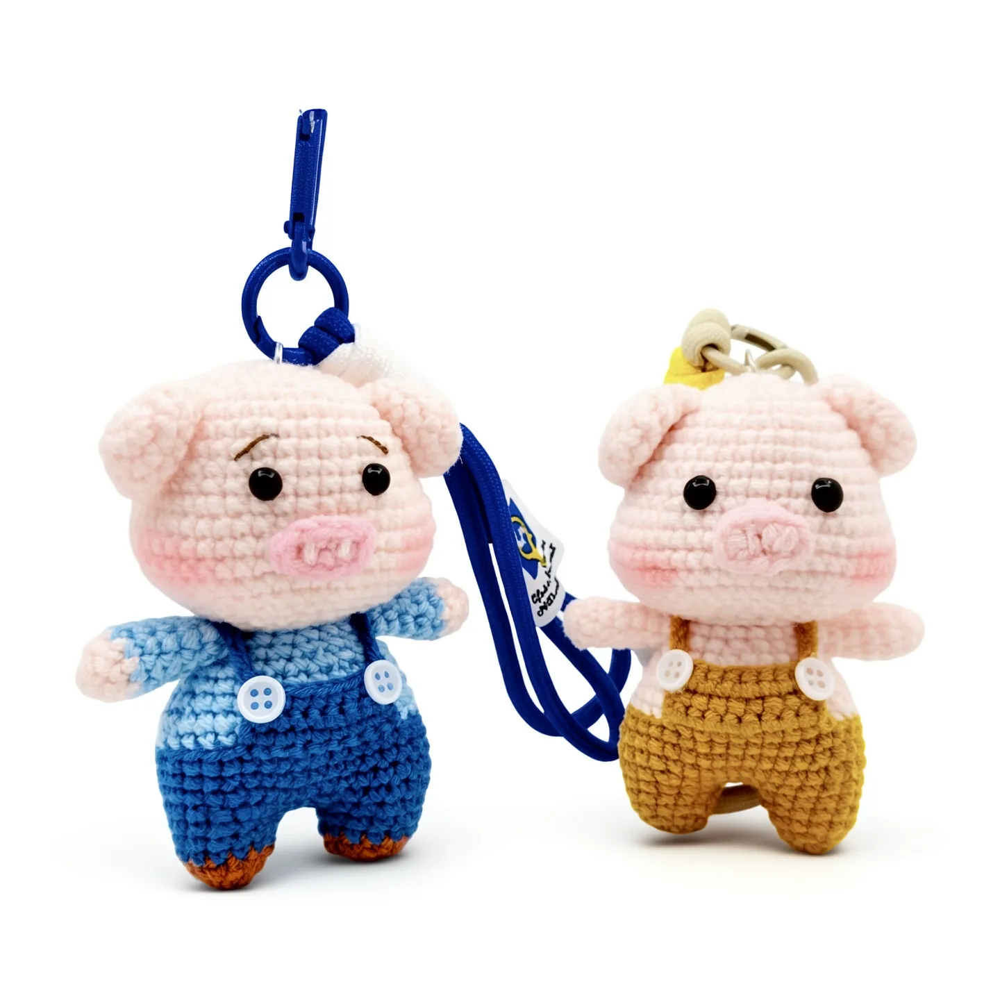Twin Prosperity Piglets crochet pig charms in blue and golden brown overalls